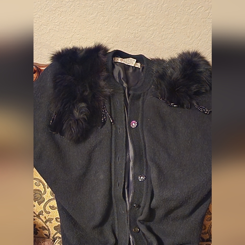 A women's black sweater with faux fur on the shoulder
